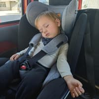 Ein Kleinkind schläft im Auto ein. 