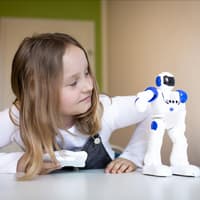 Mädchen spielt mit kleinem Roboter. 