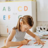 Erstklässlerin arbeitet im Heft.