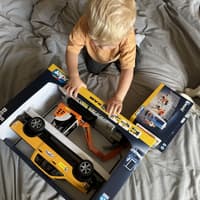 Victorias Sohn packt das Paket von Bruder Spielwaren aus.