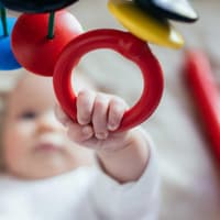 Baby greift nach einem Mobile.