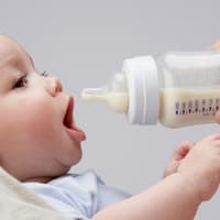 Baby wird mit Milchflasche gefüttert.