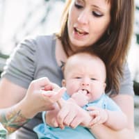 Mutter übt mit Baby und Kleinkind die Babyzeichensprache.