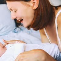 Eine Frau lächelt ihr Baby an. 