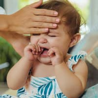 Mutter fühlt heiße Stirn eines schreienden Babys.