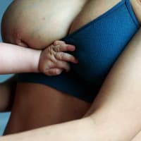 Babyarm an Mutterbrust
