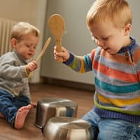 Kinder schlagen mit Kochlöffeln auf Töpfe.