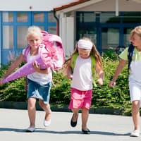 Drei Schulkinder mit einer Schultüte.
