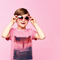Junge mit rosa T-Shirt und rosa Sonnenbrille.