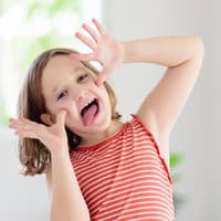 Lachen und Quatsch machen geht immer ... Dabei entwickelt sich der Humor von Kindern weiter. Kind schneidet eine Grimasse.