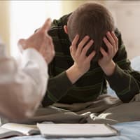 Vater schimpft mit Sohn im Schulalter
