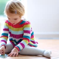 Kinder sitzen gerne im W-Sitz, wenn sie am Boden spielen. 