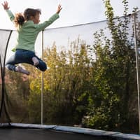 Kind springt hoch auf rundem Trampolin.