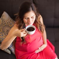 Schwangere Frau trinkt Kaffee.