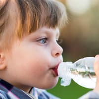 Mädchen trinkt aus einer Wasserflasche.