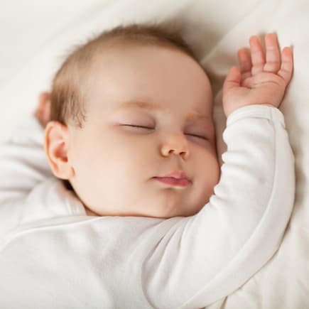 Ein Baby schläft in seinem Bett.