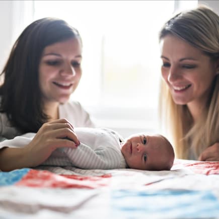 Ein Säugling und zwei Frauen