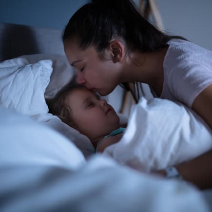 Mutter tröstet ihr Kind nach einem Nachtschreck