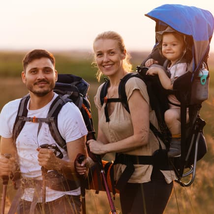 Familie beim Wandern mit der Kraxe
