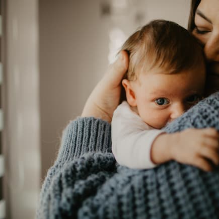 Neugeborener Junge auf dem Arm seiner Mama
