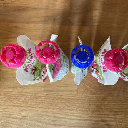 Quetschie-Fruchttüten stehen aufgereiht auf dem Tisch. 