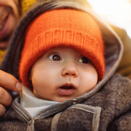 Ein Vater hält sein Baby im Arm. 