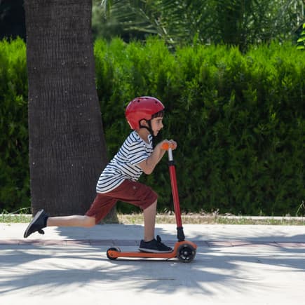 Kleines Kind fährt auf seinem Roller