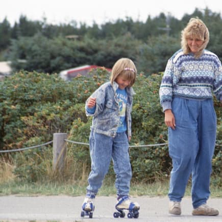 Mutter und Kind fahren Rollschuh.