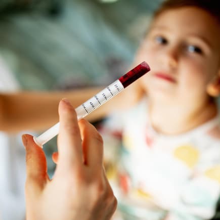 Mutter gibt ihrem Sohn Fiebersaft mit einer Pipette