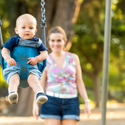 Mama mit Kind auf dem Spielplatz