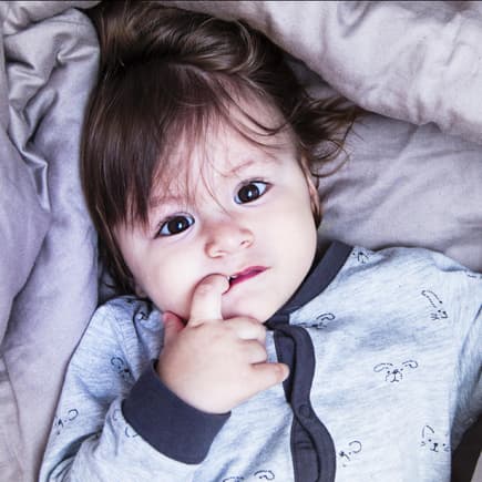 Ein kleines Kind liegt im Bett und kann nicht einschlafen.