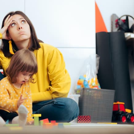 Genervte Mutter mit spielender Tochter.