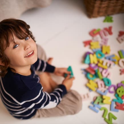 Kind spielt mit Buchstaben.