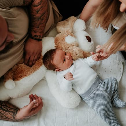 Eltern beugen sich über ihr Baby.