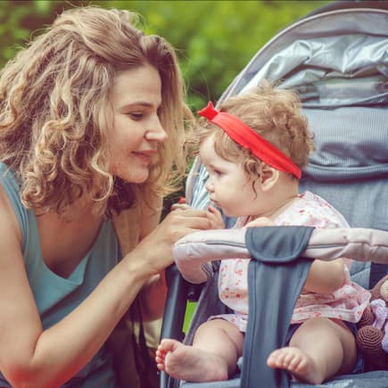 Eine Mama und ihr Baby im Buggy