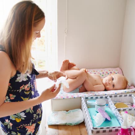 Mama wickelt Baby auf Wickeltisch