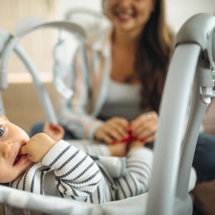 Baby liegt in Babywippe