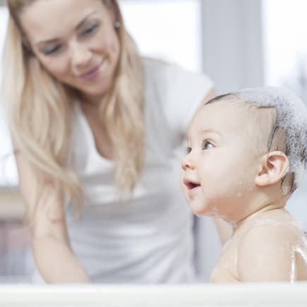 Baby sitzt in faltbarer Babywanne