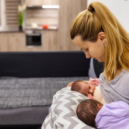 Mama stillt ihre Zwillinge auf Stillkissen