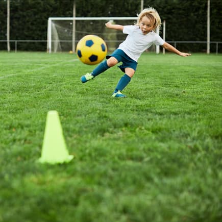 Eine Junge schießt einen Fußball