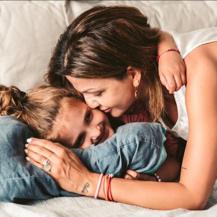 Eine Mutter kuschelt mit ihrer Tochter.