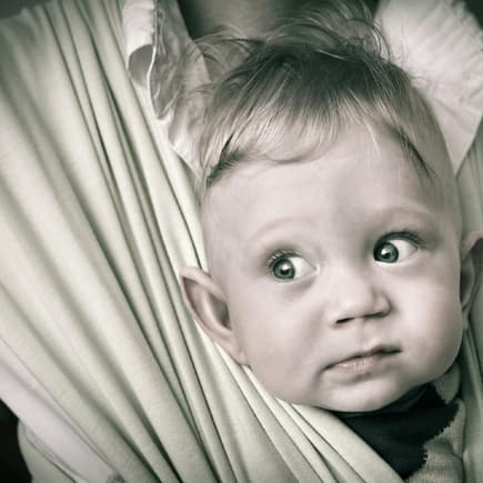 Herr der Ringe: Kleiner Elben-Junge guckt lustig aus der Babytrage heraus. 