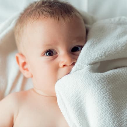 Baby auf weißer Decke.