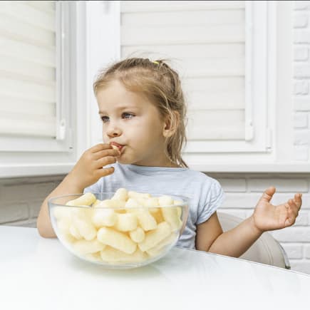 Mädchen futtert Maissnacks aus einer Schüssel