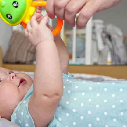 Baby greift nach Beißring