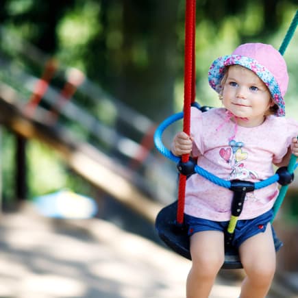 Baby sitzt in Babyschaukel