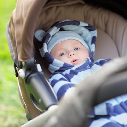 Baby liegt im Kinderwagen