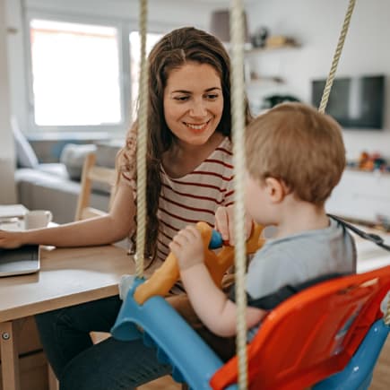 Kind sitzt in Babyschaukel