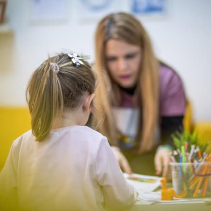 Erzieherin mit einem kleinen Kind in einer Kita.