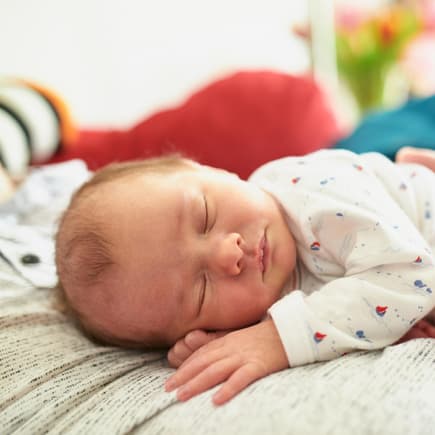 Ein Baby-Mädchen schläft auf der Brust seines Vaters.